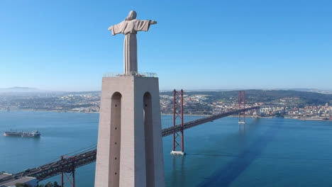 view from almada to lisbon with the arms of the christ the king statue