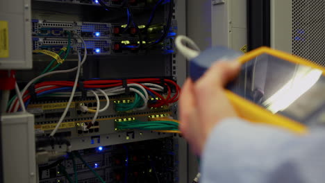 technician using digital cable analyzer on server