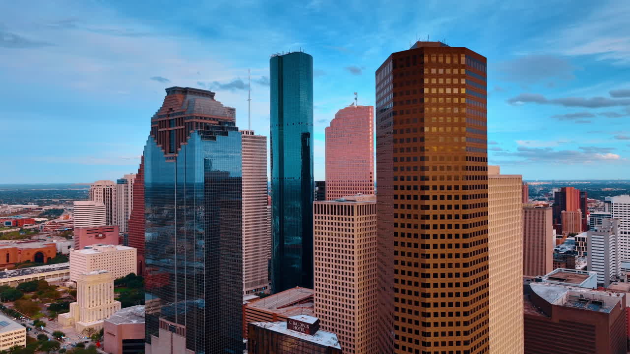 Houston, USA, 24 November 2025: Dense cluster of skyscrapers in downtown Houston Texas at dusk. Aerial view of high-rise office buildings with glass and stone facades under a blue sky
