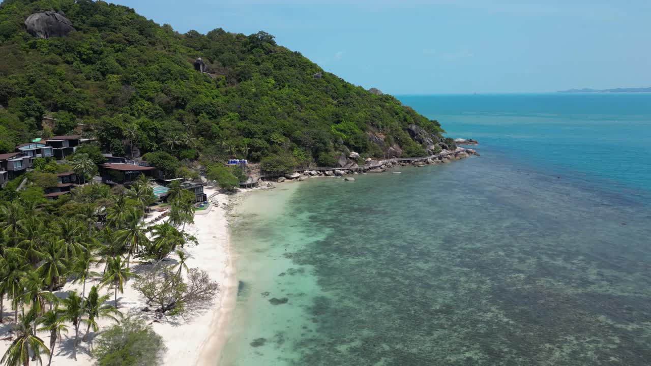 Drone flying forward over white sand tropical beach with blue ocean