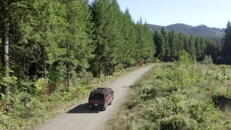 VW-Van-vintage-van-driving-through-forest-aerial-view-4k-drone