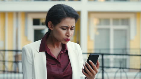 Disappointed-businesswoman-having-video-chat-outside