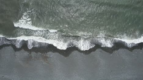 waves breaking on a shingle beach at low tide on the copper coast waterford on a warm july day