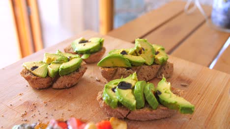 close up view of nutritious breakfast toast of homemade bread along with pieces of green avocado