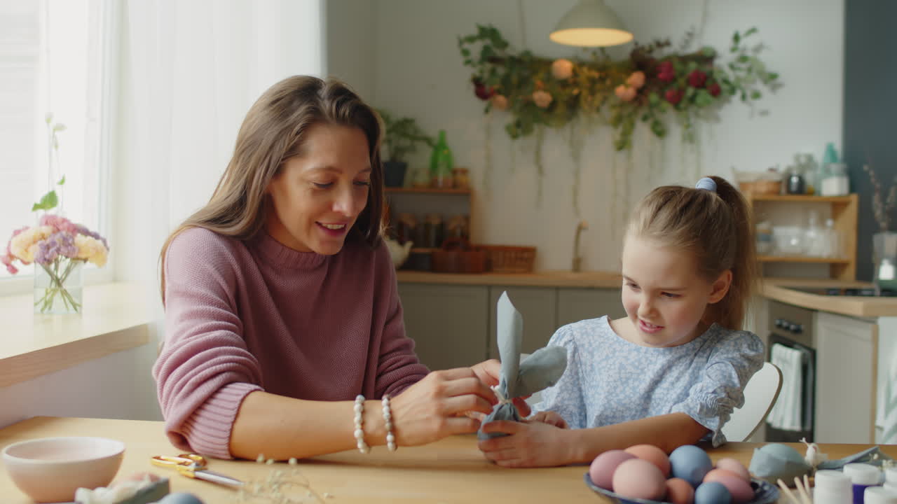 Girl Decorating Easter Eggs with Mother