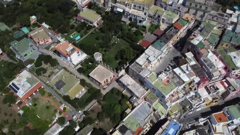 drone flying above the island of procida waterfront housing and revealing marina di procida port yacht docks at sea, italy