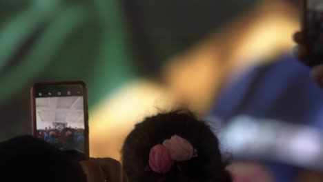 person taking a photo of a crowd at an indoor event