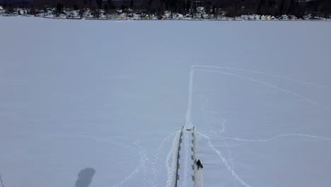 Aerial-drone-footage-of-a-lighthouse-over-a-frozen-lake-in-America-during-winter-in-Chautauqua-county-in-lakewood,-new-York