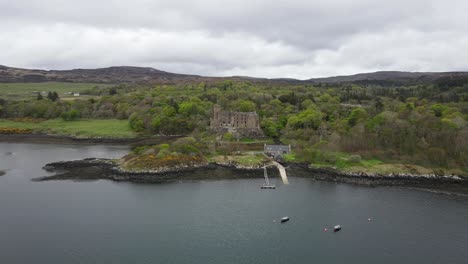 Aerial-view-of-Dunvegan-old-medieval-castle-on-the-shore-of-the-Isle-of-Skye,-Scotland