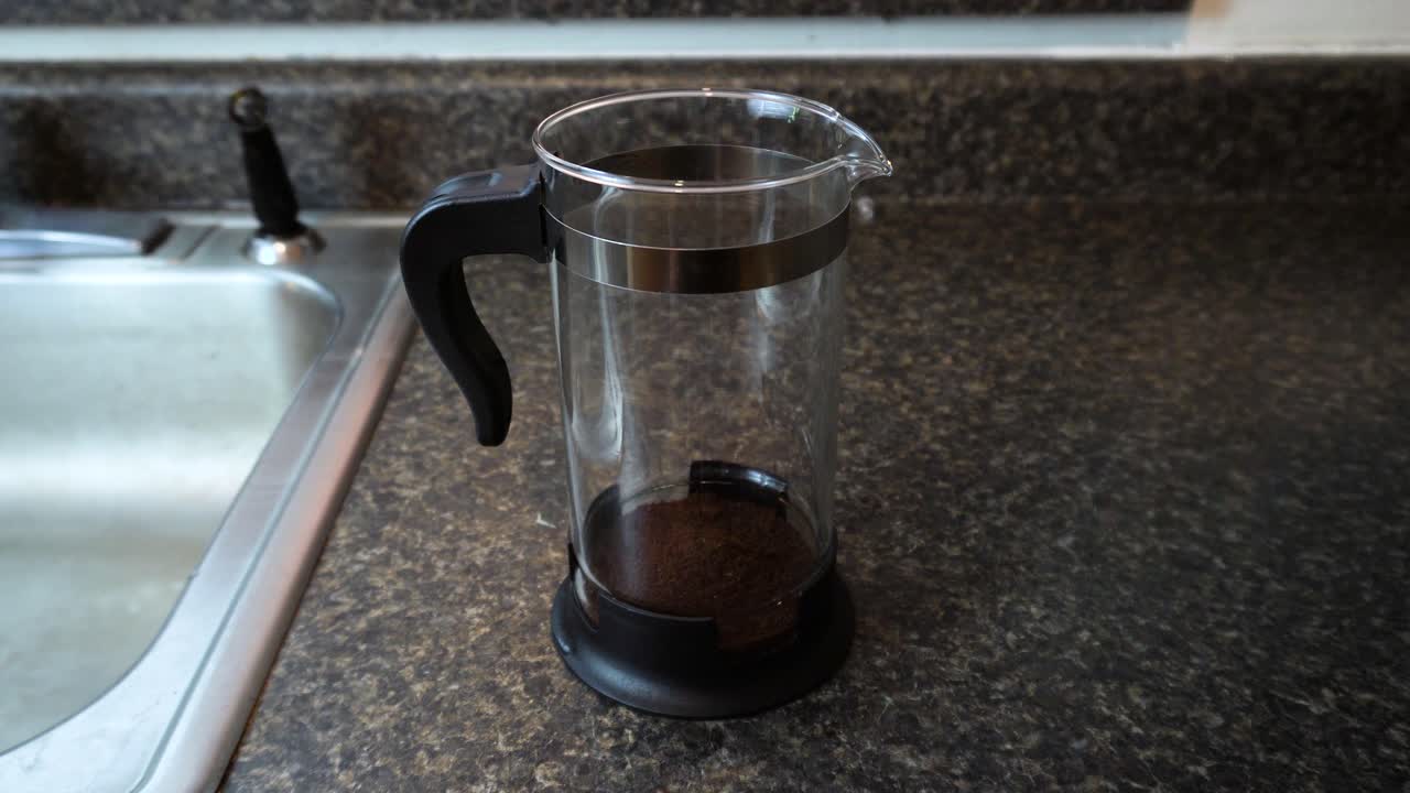 프렌치 프레스 커피 메이커에 커피 찌꺼기를 떠서