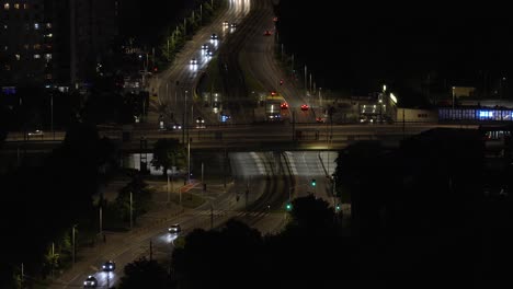 aerial shot of warsaw at night, showcasing a busy road with cars and lights