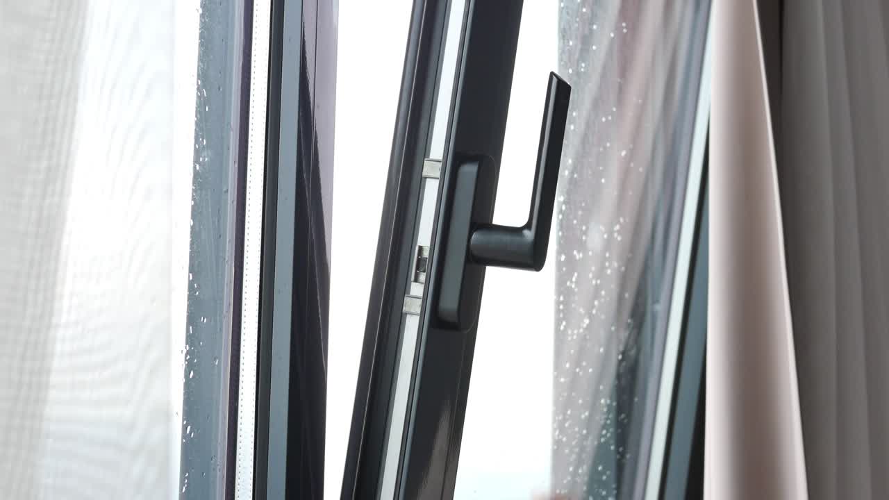 비가 오는 날 창문을 열고 있는 사람