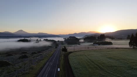 Aerial-view-of-a-road-leading-to-a-landscape-covered-in-dew