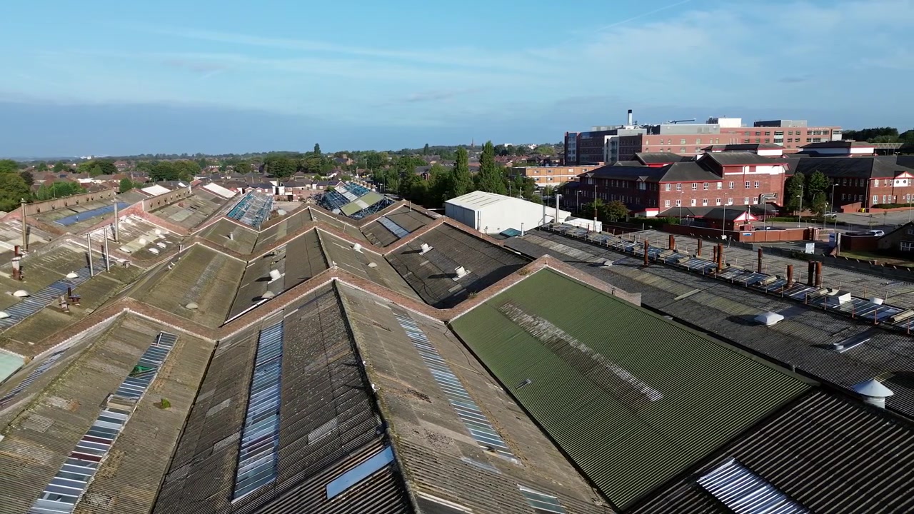 Glen Dimplex industrial factory aerial circling view across workshop rooftops and Whiston hospital