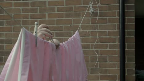 woman hanging clothes on the washing line with wooden, pegs-1