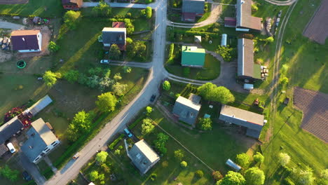 Top-down-view-of-residential-area-during-golden-hour-with-village-roads