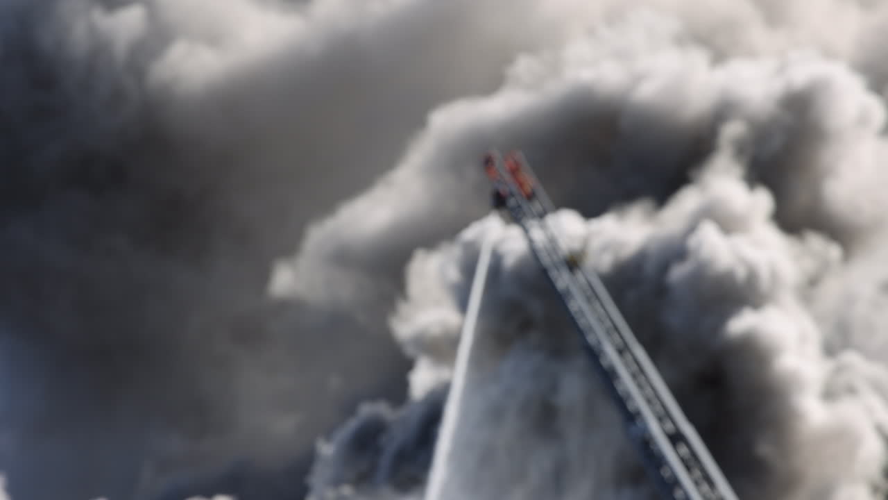 확장 된 사다리 에 있는 소방 호스 는 배경 에 연기 의 구름 이 있는 불 에 물 을 스프레이 한다