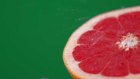 drops of water falling on a slice of ripe grapefruit.