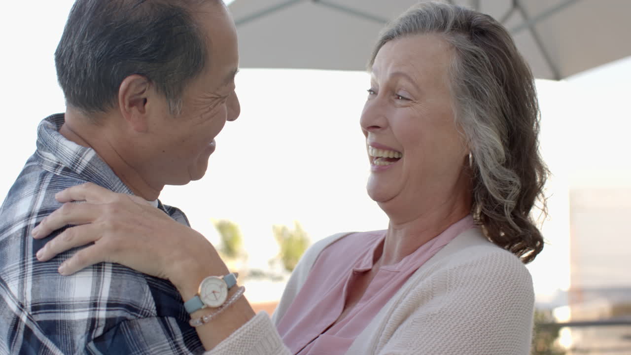Laughing and embracing, senior couple enjoying vacation time together