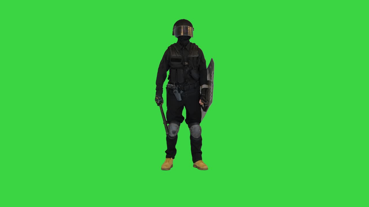 Spazzatura lanciata contro un poliziotto di unità speciale con lo scudo alzato su Green Screen, Chroma Key.