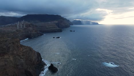 Turbinas-Eólicas-En-Las-Montañas,-Generan-Energía-Verde,-Al-Lado-Del-Mar,-A-Orillas-Del-Océano