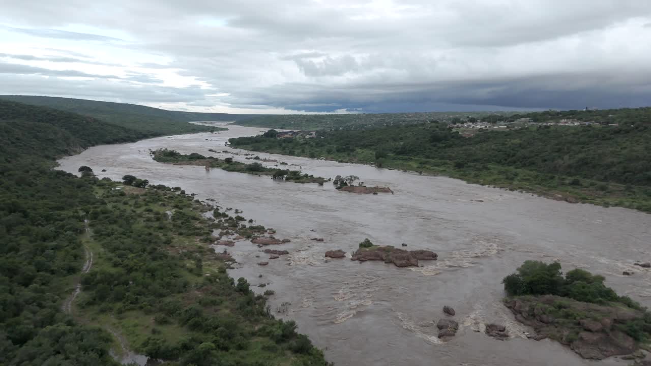 Riprese aeree cinematografiche fluide che scendono lentamente su un fiume in piena nella parte meridionale del Parco nazionale Kruger, vicino al confine con il Mozambico