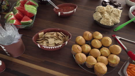 pan of party table of super bowl theme food and snacks on table for football