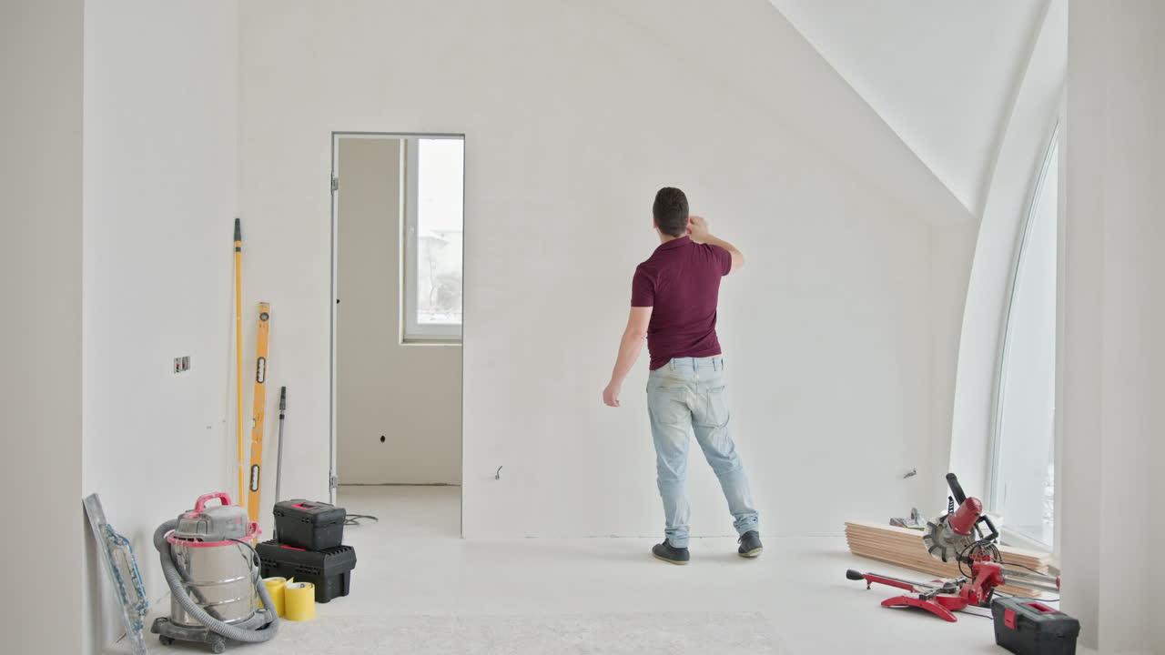 trabalhador da construção a lixar a parede