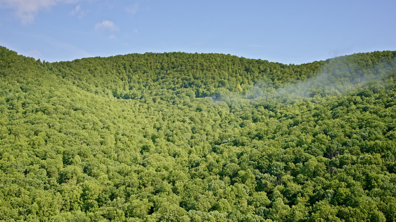 Aerial journey over the Smoky Mountains where valleys drown in silver mist