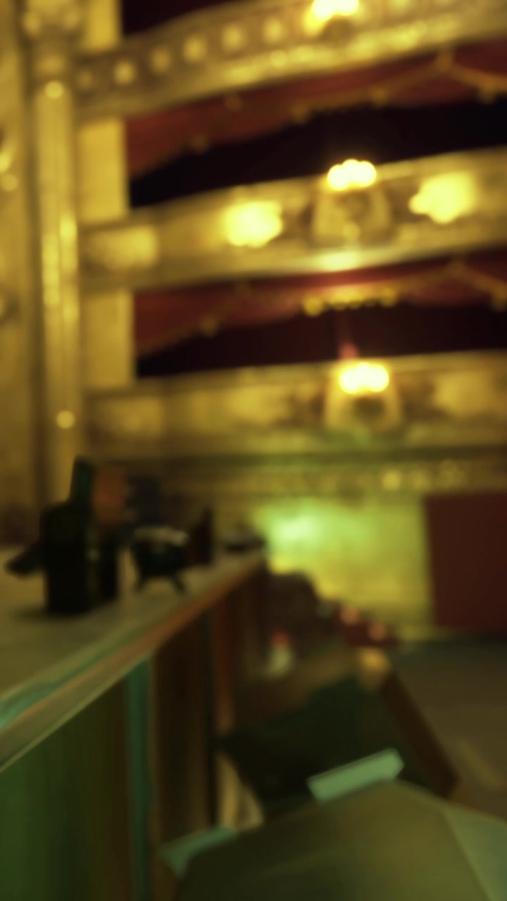 Asientos del público y vista desde el balcón en un teatro durante una función nocturna