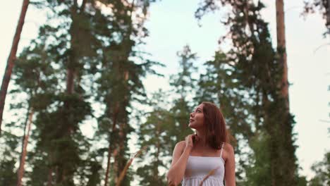woman looks up a tree, admires the pines. walking in the woods, admiring nature. 4k, 10bit, prores