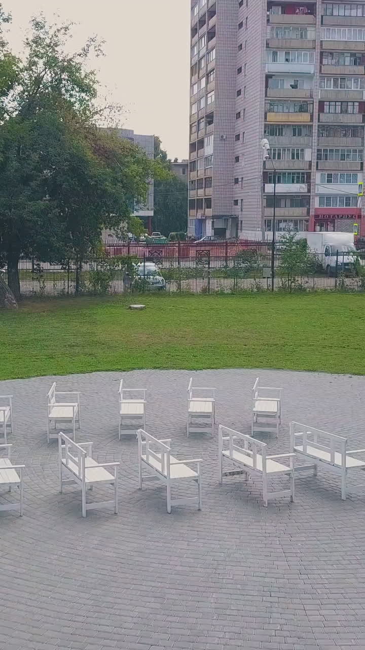 stylish wedding ceremony venue arch decorated with pink fabric and flowers and guest benches in green park aerial view