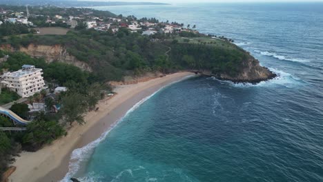 Drone-video-takes-us-to-Coral-beach,-a-pristine-sandy-shoreline-in-Puerto-Escondido,-Oaxaca