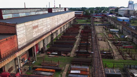 aerial view of an industrial railroad facility with stacked materials and train cars