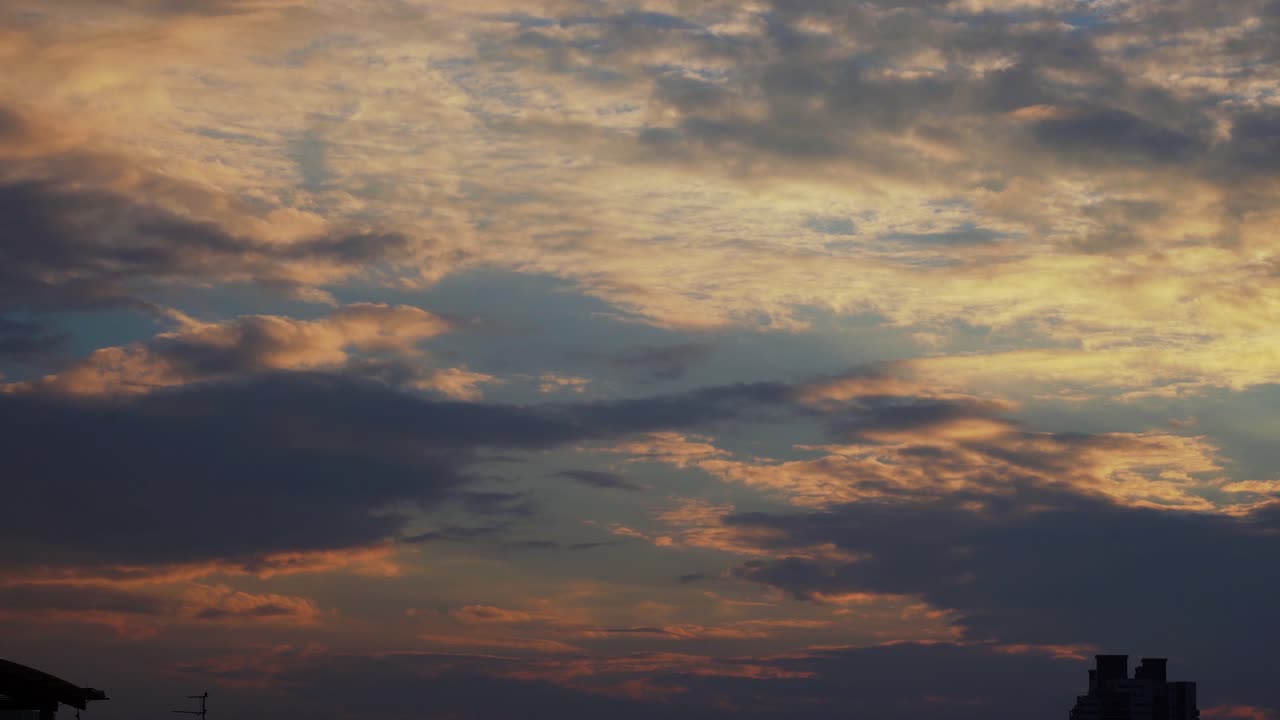 A colorful amazing sunset surfing clouds, blue and yellow, orange sky, time lapse, 4K video