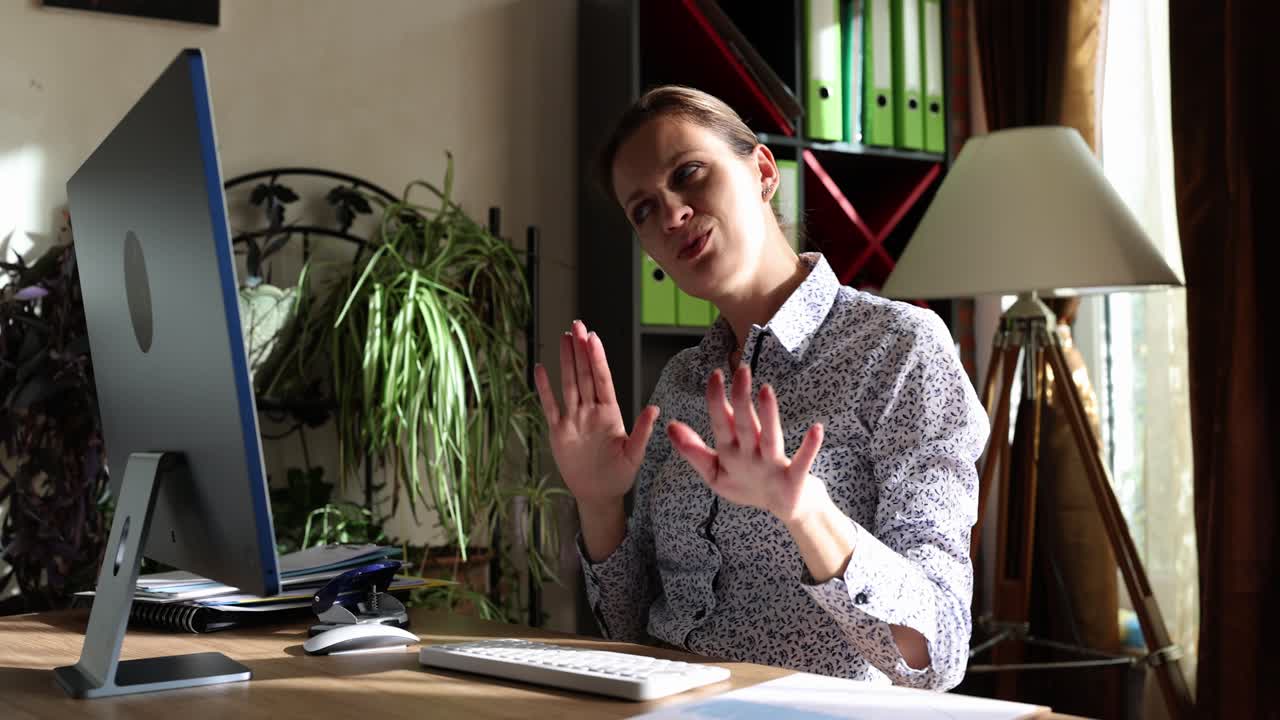 Woman talking in front of computer in office