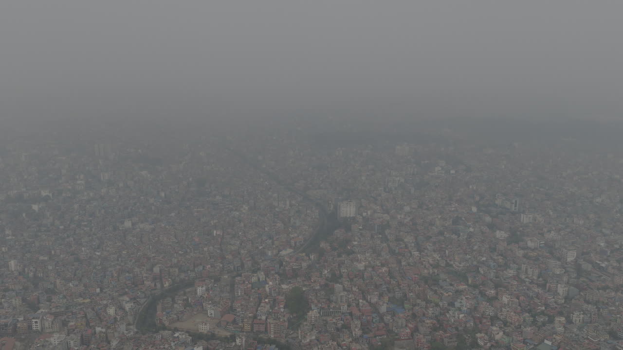 Drone aerial shot of Kathmandu city under smoky haze with poor visibility and unhealthy air quality, showing severe urban air pollution in Nepal
