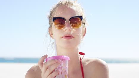 Retrato-De-Cerca-De-Una-Hermosa-Joven-Adolescente-Bebiendo-Agua-De-Un-Vaso-De-Plástico-Rosa-En-Una-Playa-Tropical-A-Cámara-Lenta