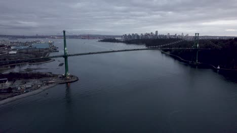 lions gate bridge at evening with city in background on cloudy day, vancouver in canada