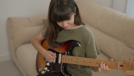 Teen-girl-learns-to-play-the-guitar