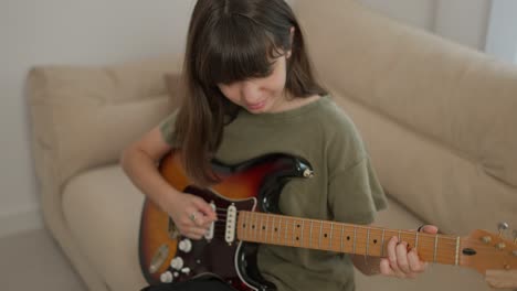 teen girl learns to play the guitar