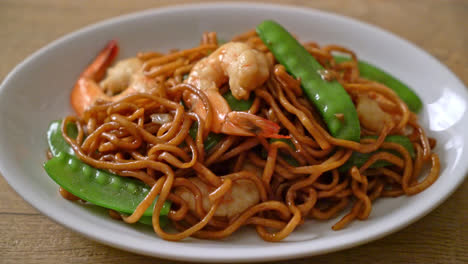 stir-fried yakisoba noodles with green peas and shrimps - asian food style