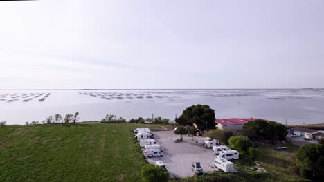 The-oyster-farm-floats-gracefully-on-the-water,-a-cluster-of-structures-and-nets-designed-to-nurture-and-cultivate-these-prized-shellfish