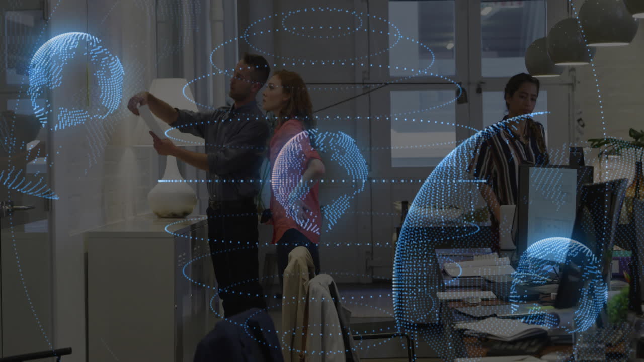 Digital globe animation over colleagues discussing documents in modern office
