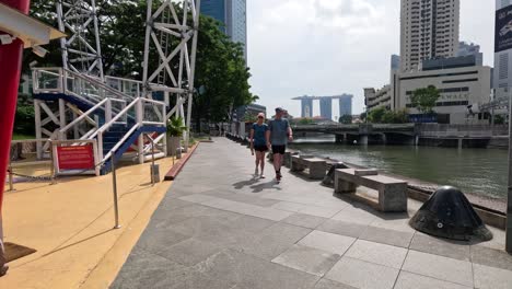 pedestrians and cyclists on sunny riverside path.