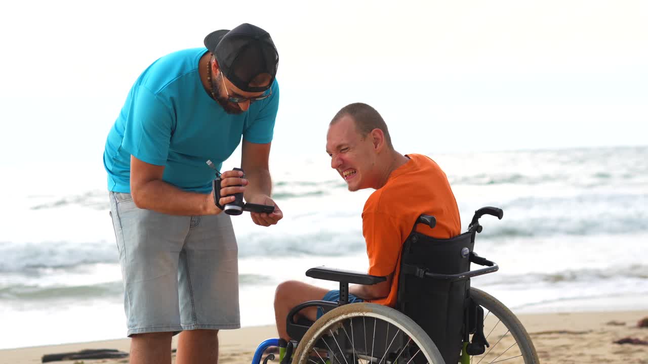 Two men on the beach, one in a wheelchair