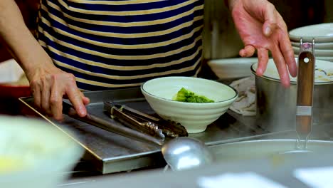 el chef prepara sopa de fideos en la cocina de hong kong