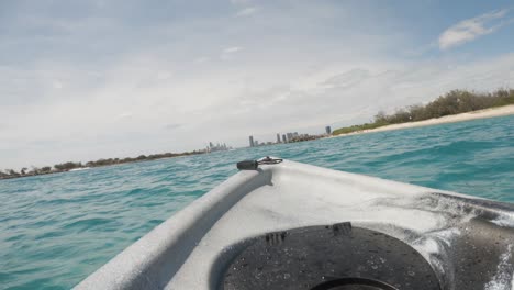 Fpv-De-Un-Kayak-A-La-Deriva-En-El-Océano-Hacia-El-Horizonte-De-Una-Ciudad