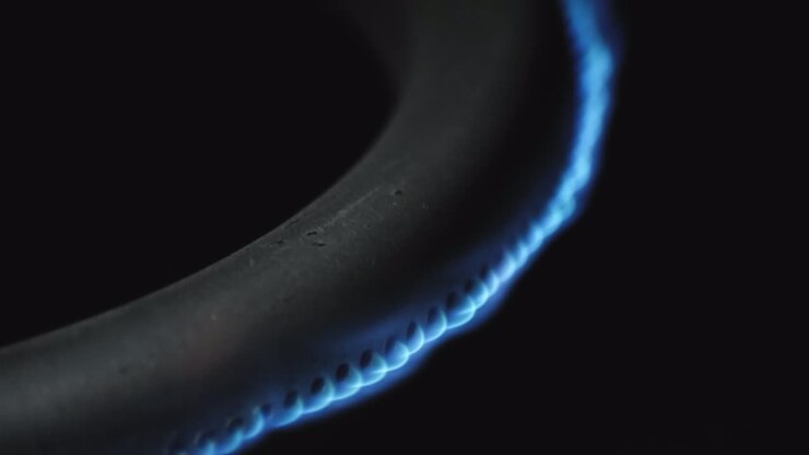Burning gas burner in the oven close-up on a black background. 4k macro raw video.
