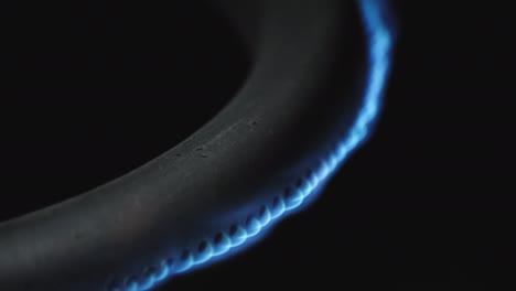 quemador de gas en el horno de primer plano en un fondo negro. video crudo macro 4k.